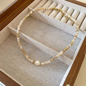 Collana artigianale in conchiglia con perla d'acqua dolce e dettagli oro 18k