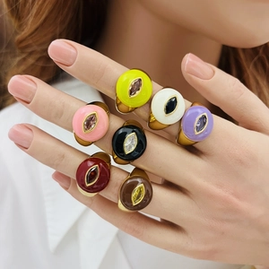 Detailed view of colorful enamel heart rings with marquise zircons on a model's hand
