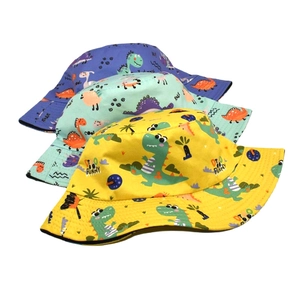 Detailed view of three cotton kids sun hats with colorful cartoon dinosaur prints