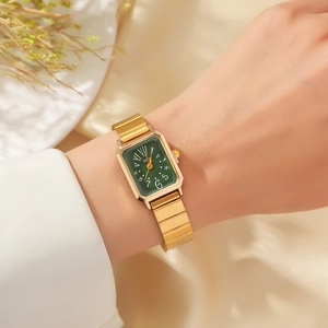 Details einer eleganten goldenen Rechteck-Uhr mit grünem Zifferblatt und Metallband