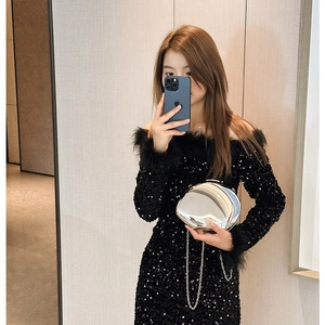 Silver oval metal clutch bag with mirror finish and delicate chain for elegant styling