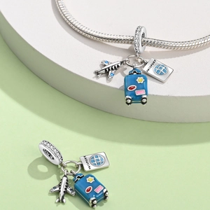 Travel-themed silver bead charm featuring a blue plane, suitcase and passport pendant