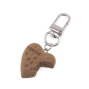 Dettaglio del portachiavi a biscotto a forma di cuore con texture cioccolato e moschettone