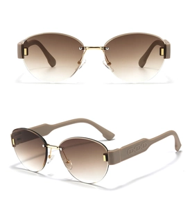 Detail view of oval rimless sunglasses with brown gradient lenses and gold bridge