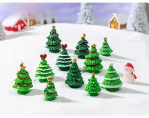 Miniature Christmas resin trees and snowman figurines in a snowy village scene