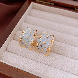 Vintage 18k gold plated floral earrings with light blue enamel petals in a jewelry box