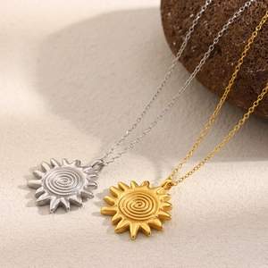 Detail of sun pendant necklaces in gold and silver finish with spiral sunray pattern