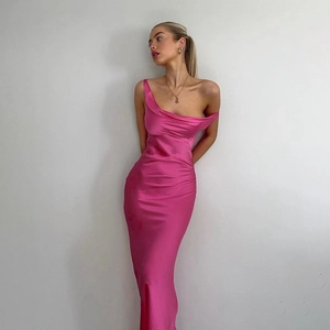 Détail de la texture satinée magenta élégante et de la coupe asymétrique de cette robe longue