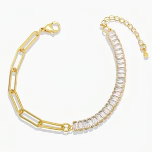 Close-up of golden paperclip chain bracelet with baguette-cut zircon stones and lobster clasp