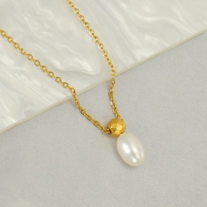Golden stainless steel necklace with hammered metal bead and white teardrop pearl pendant