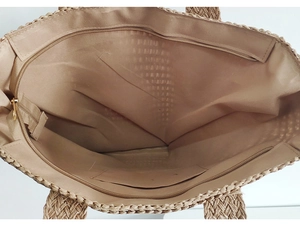 Detailed view of the straw tote bag's spacious interior with zipper pocket and lining