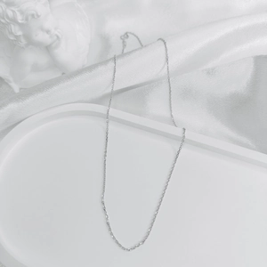 Detailed close-up of a minimalist S925 sterling silver thin cross chain without pendant