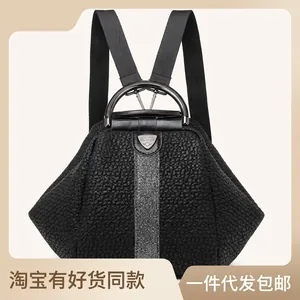 Detail of black pebbled leather backpack with a metal handle and vertical grey stripe