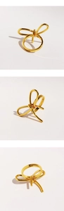 Three angles of a metallic gold bow ring showing the intricate knots and polished finish