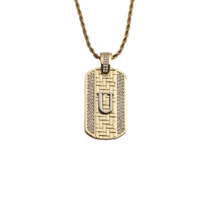 Détail du pendentif rectangulaire doré avec lettre U argentée et pierres de zircone brillantes