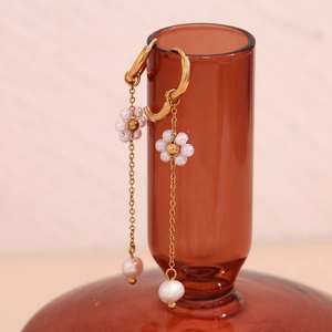 Detail of 18K gold-plated chain earrings with white flower charms and hanging pearls