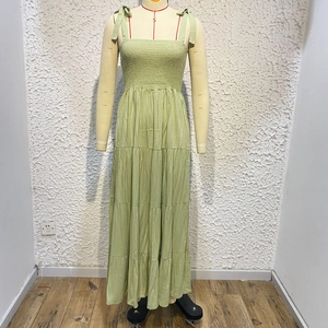 Detail of green tiered sun dress featuring pleated chest and tie-up bow shoulder straps