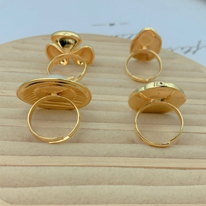 Set of four gold floral and geometric open rings displayed on a beige velvet tray