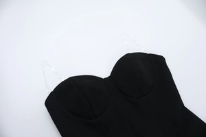 Close-up of black corset dress fabric texture and clear plastic shoulder straps