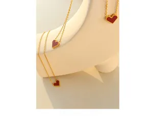 Detail of red heart pendant with gold milgrain edges on a fine cross chain