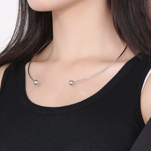 Close-up of a silver minimalist open torque necklace with spherical beads on neck