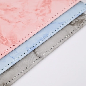 Close-up of marble texture PU leather passport covers with neat white stitching detail