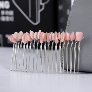 Detail of handmade silver hair comb with rose quartz crystals wire-wrapped on metal teeth