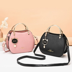 Fashionable shell-shaped cat charm handbag in pink and black faux leather with gold handles