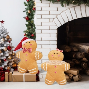 Detail of gingerbread man plush pillows with festive decor by a cozy white fireplace