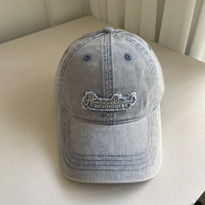Detailed view of light blue washed denim baseball cap with Abundant embroidered patch