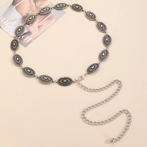 Detail of silver bohemian metal waist chain with oval floral carvings and adjustable link