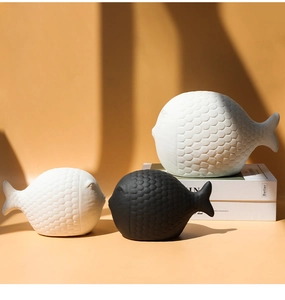 Detalle de figuras de peces de cerámica moderna con textura de escamas en blanco y negro