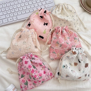 Flat lay of diverse seersucker drawstring bags with cute floral and animal patterns