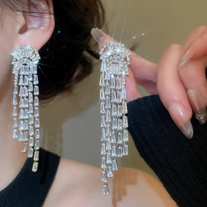 Détail de boucles d'oreilles méduse en argent avec zircons brillants et glands