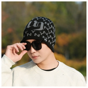 Close-up of winter knit beanie featuring grey NY pattern and side logo embroidery
