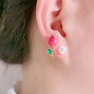 Close-up of pink tulip earring with pearl detail worn by model for elegant style