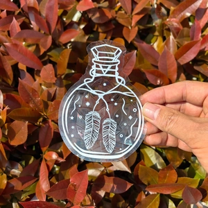 Close-up of a potion bottle rainbow suncatcher window decal with celestial patterns