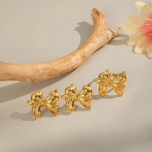 Close-up of golden 3D bow rings on natural wood branches for a luxury jewelry look