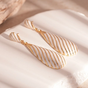 Macro detail of zebra pattern water drop earrings with vintage spiral enamel texture