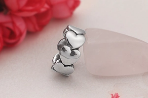 Macro shot of silver heart-shaped band ring resting on a pink quartz stone