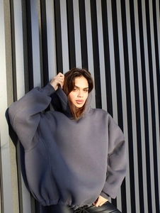 Detail of oversized dark grey hoodie featuring embroidery and structured drop shoulder fit