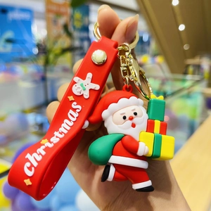 Close-up of a 3D Santa Claus silicone keychain with red strap and colorful gift box charms