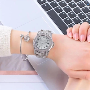 Detailaufnahme einer silbernen Uhr mit römischen Ziffern und passendem Armreif