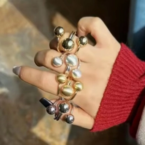Anello orbitale regolabile minimalista con sfere dorate indossato da una modella