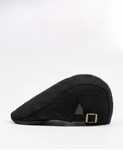 Detail of black flat cap side showing breathable mesh texture and metal adjustment buckle