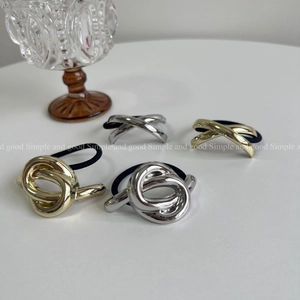 Close-up of knot and geometric metal hair ties in gold and silver finish with elastic band