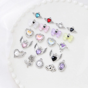 DIY bow and heart pendant charms with zirconia and pearls on a white silk tray