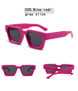 Detail view of bold magenta rectangle sunglasses with dark gray lenses and thick frame