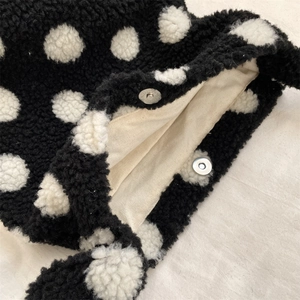 Detail of magnetic silver clasp and white canvas lining on plush polka dot handbag
