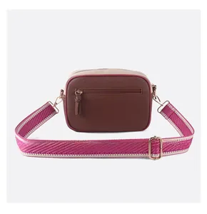 Détail du sac bandoulière bicolore avec texture litchi et bandoulière tissée